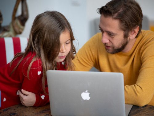 photo d'un père et sa fille devant un ordinateur